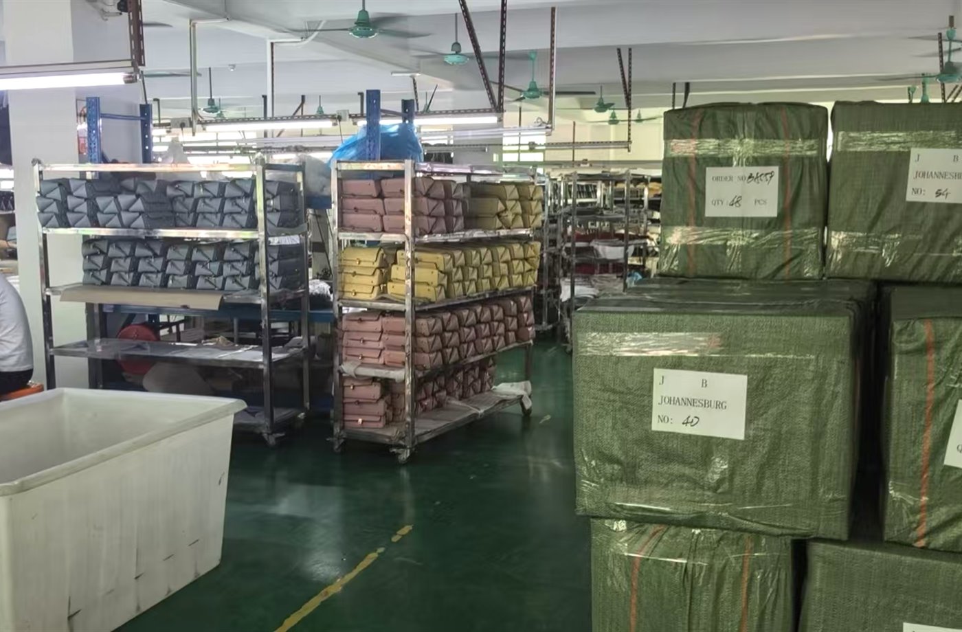 Packed handbag cartons and production racks inside workshop
